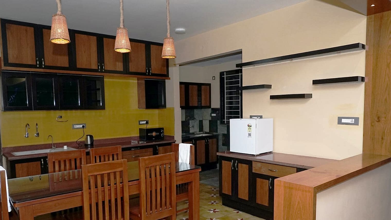 Wood and glass kitchen cabinets under three woven pendant shades.