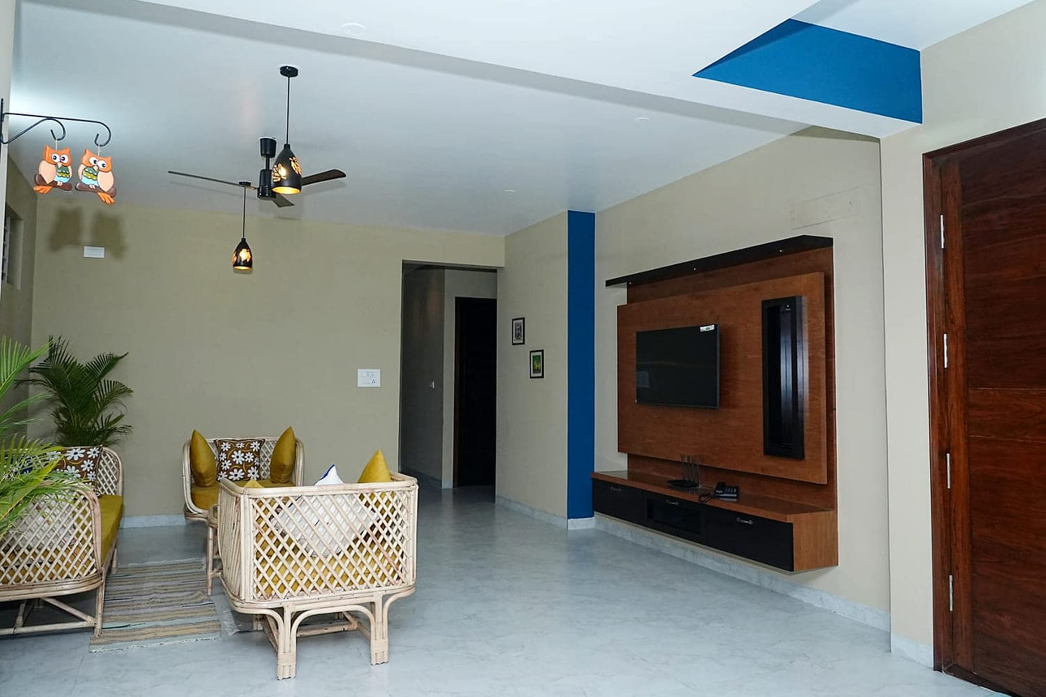The living room of one floor, with cane seating and daylight from a tall window.
